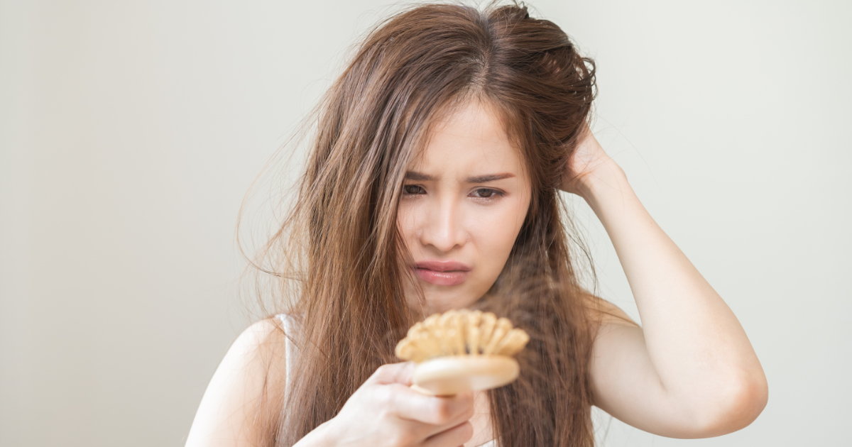 Foto meisje met haarproblemen die naar haar haarborstel kijkt en niet blij is met de haaruitval